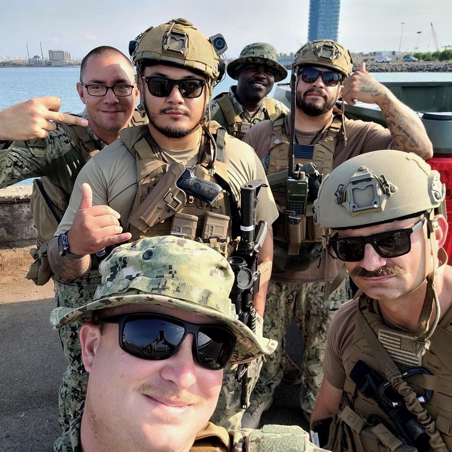 The crew on the pier after a run, helmets and boonie hats on, all grins